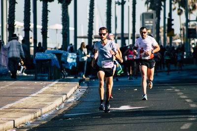 People running on street in city