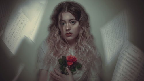 Portrait of beautiful young woman against black background