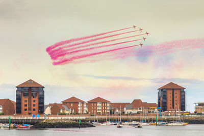 Boats flying over water against sky