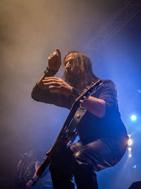 Low angle view of person playing guitar at music concert