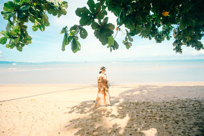 Rear view of woman standing on beach