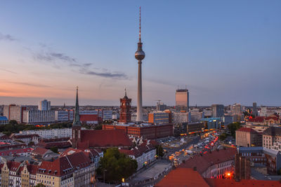 Buildings in city against sky during sunset