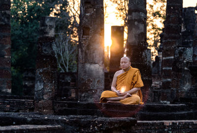 Monk meditating at old ruin temple