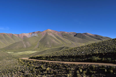 Scenic view of mountains against clear blue sky