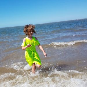 Full length of shirtless boy standing in sea