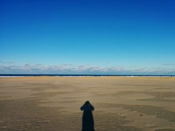 Scenic view of beach against clear blue sky