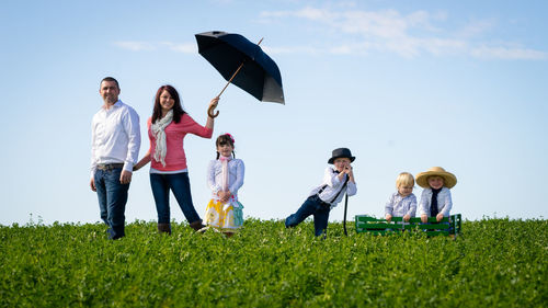 People on grassland against sky