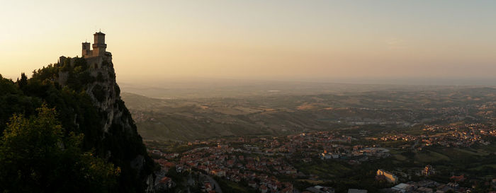 Aerial view of buildings in city at sunset