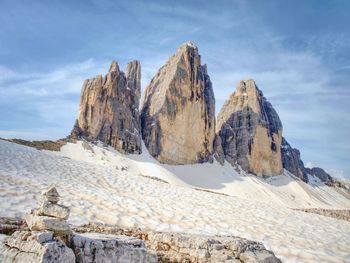 Sharp stones stacked into pyramid. mountain ridge in italian dolomites alps in early summer.