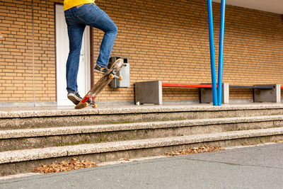 Low section of man skateboarding on staircase in city