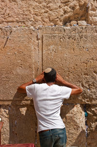 Rear view of man standing against wall