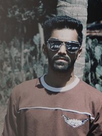 Portrait of young man wearing sunglasses standing outdoors