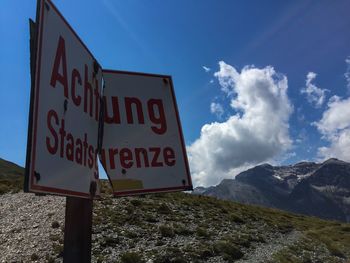 Information sign on landscape against sky