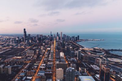 High angle view of city by sea against sky