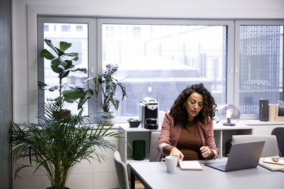 Pregnant female professional working at desk in office