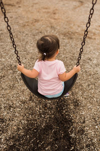 Girl playing on swing at playground