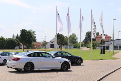 Cars on street by buildings against sky in city