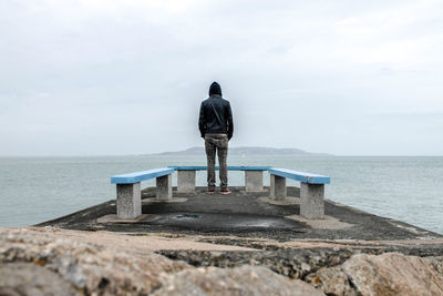 Rear view of a man overlooking calm lake