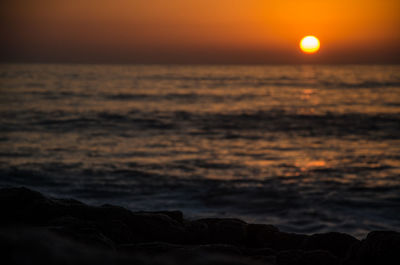 Scenic view of sea against romantic sky at sunset