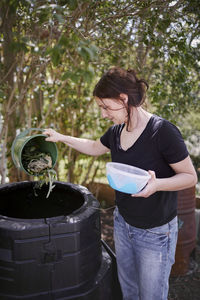 Woman throwing out organic waste