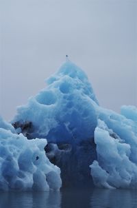 Scenic view of icebergs in snow against sky