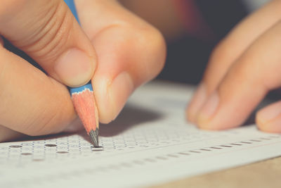 Close-up of hand holding pencil on paper