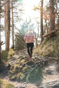 Rear view of woman walking in forest