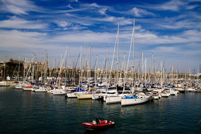 Sailboats moored in sea against sky