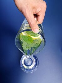 Human hand pouring water in drinking glass