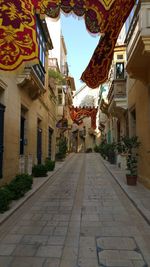 Footpath amidst buildings against sky