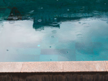 High angle view of raindrops on swimming pool