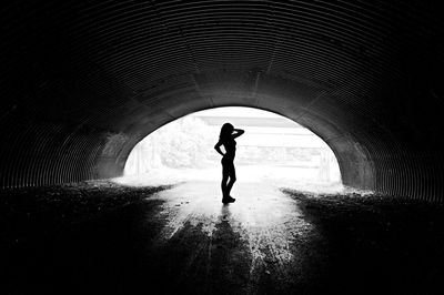 Woman standing in tunnel