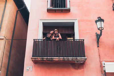 Portrait of young man with girlfriend standing at balcony