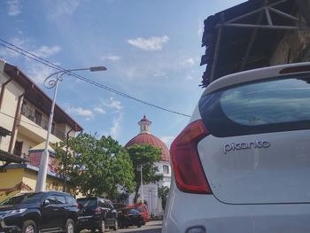 Low angle view of cars on city against sky