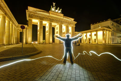 Statue in city at night