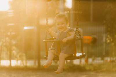 Portrait of young woman sitting on swing