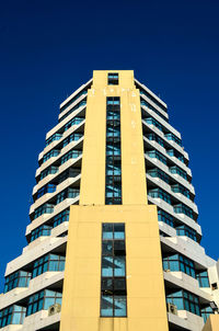 Low angle view of modern building against clear blue sky