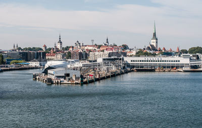 Boats in sea with city in background