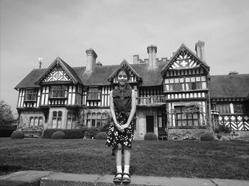 Portrait of man standing outside house against sky