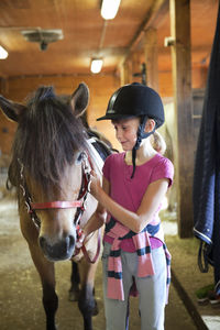 Girl with horse in stable