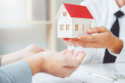 Midsection of couple holding hands in house