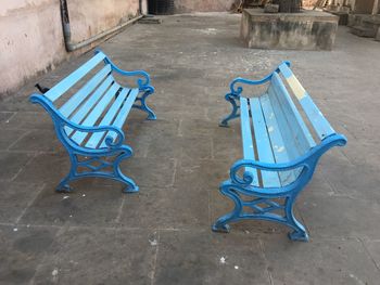 High angle view of empty chairs on table against wall