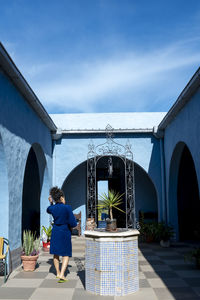 Woman in robe walking outdoors in a countryside house.