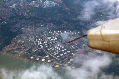 High angle view of airplane flying over buildings in city