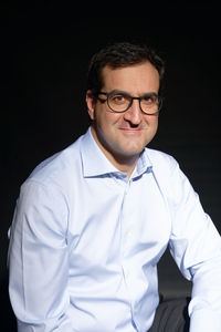 Portrait of man wearing mask against black background