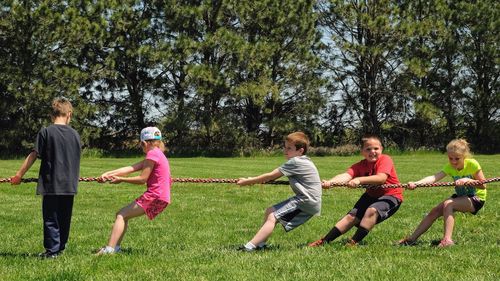 Children playing soccer on grass in park