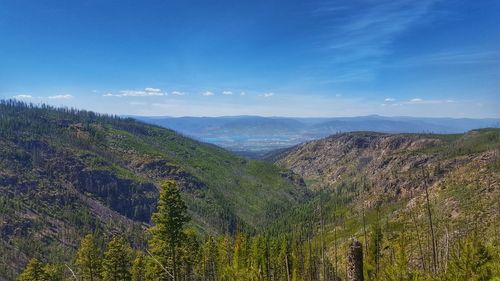Scenic view of mountains against blue sky