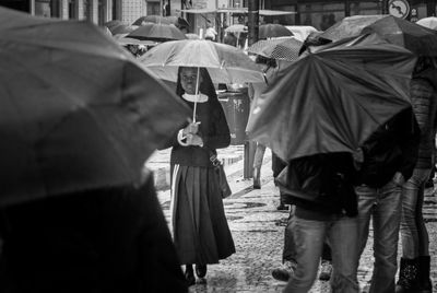 Rear view of people walking on street in rain