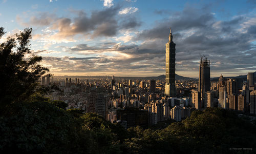 View of cityscape against cloudy sky