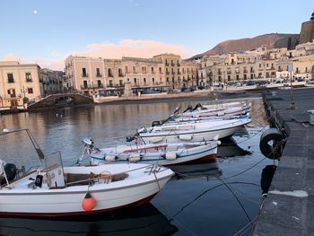 Boats moored in canal by buildings in city